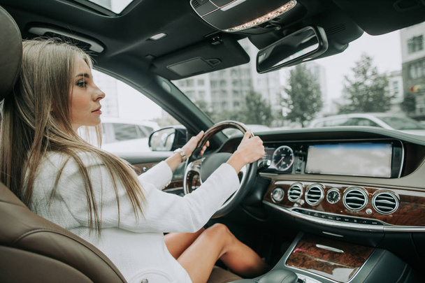 Focused young businesswoman locating in new car - Photo, image