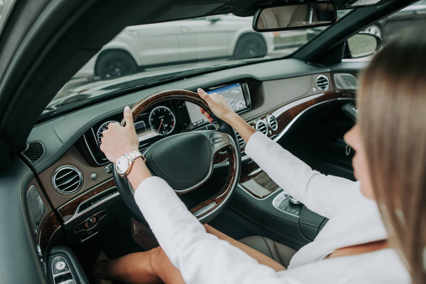 Woman hands keeping steering wheel in car - Foto, afbeelding