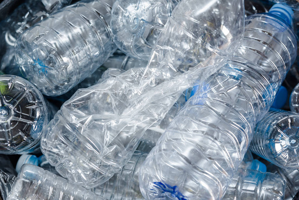 Plastic flessen in zwarte vuilniszakken wachten te worden genomen om te recyclen. - Foto, afbeelding