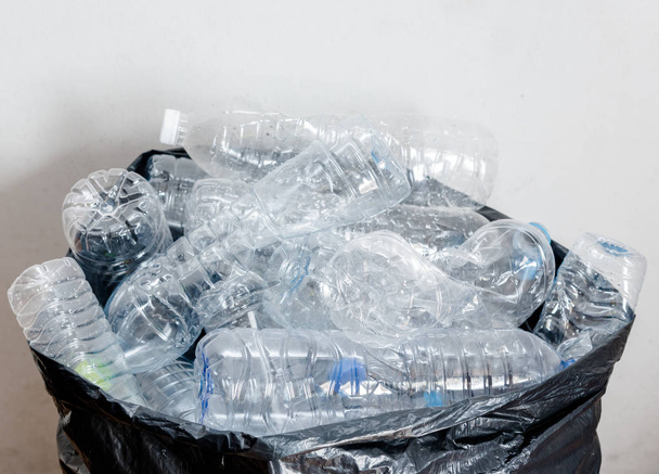 Plastic bottles in black garbage bags waiting to be taken to recycle. - Photo, Image