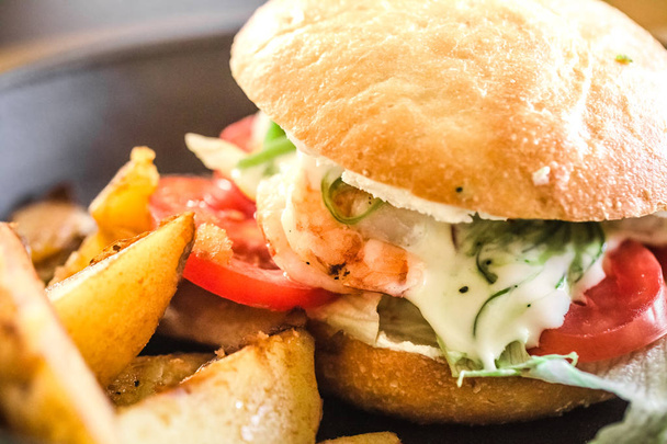 smakelijk sandwich met aardappelen op een bord in een café, concept van fastfood - Foto, afbeelding