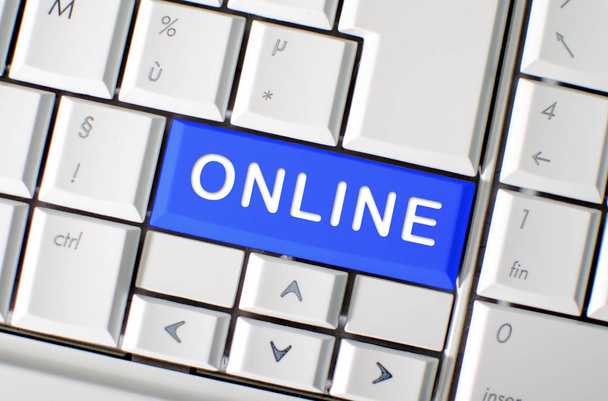 青色のコンピューターのキーボードのキーに印刷された単語オンライン - 写真・画像
