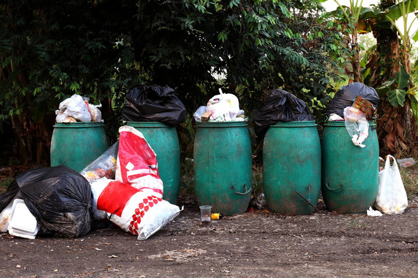 Bin, Bin σκουπίδια και πολλά σωρό από σακούλες σκουπιδιών στο έδαφος, Bin απόβλητα πλαστικά για ανακύκλωση απορριμμάτων, αποβλήτων πολλά, ρύπανση απόβλητα στο χωριό - Φωτογραφία, εικόνα