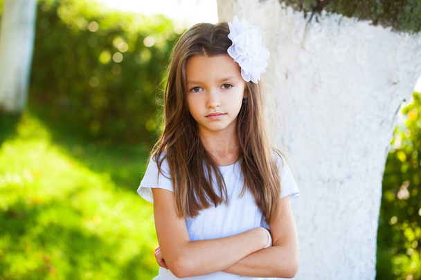 Portrait of a beautiful young brunette little girl, summer outdoors - Fotó, kép