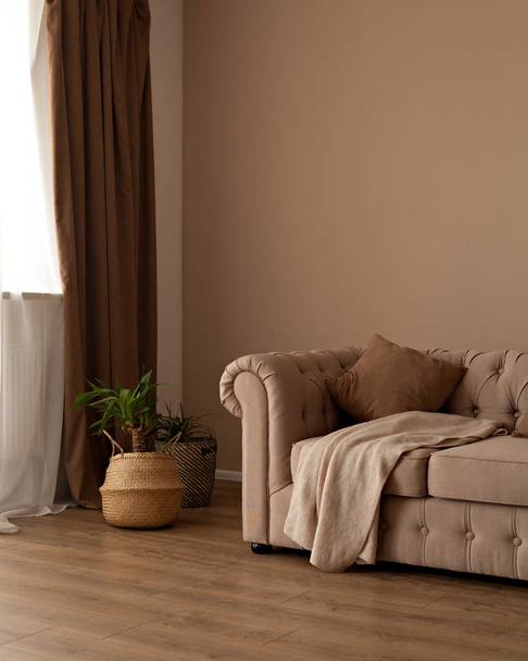 Belo sofá têxtil bege chesterfild nos interiores da sala
 - Foto, Imagem