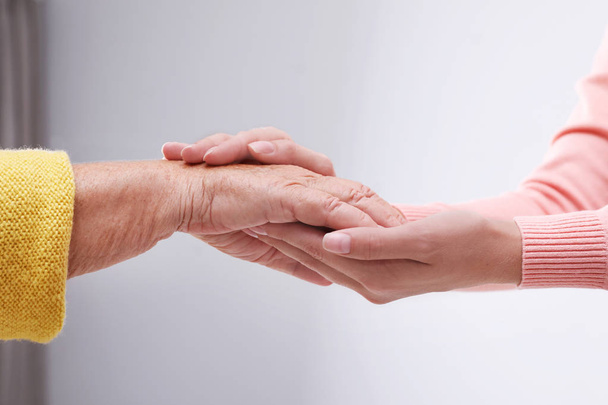 Les gens se tiennent la main à l'intérieur. Service d'aide et de soins aux personnes âgées
 - Photo, image