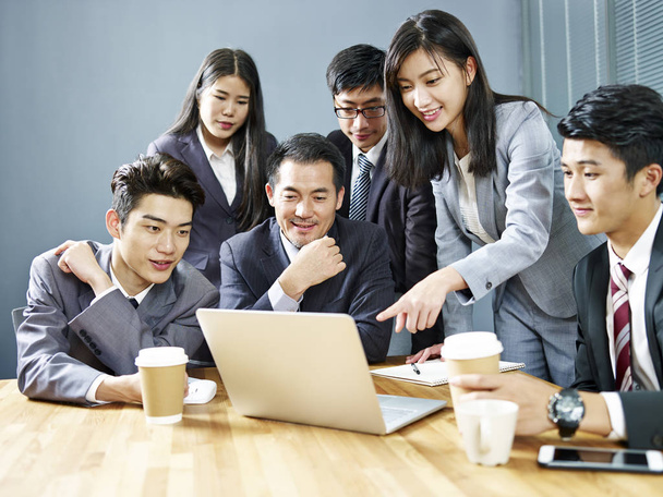 オフィスでラップトップ コンピューターを使用してビジネス結果を見直しアジア企業人のチーム - 写真・画像