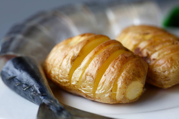 Patatas doradas al horno con caballa de arenque
 - Foto, imagen