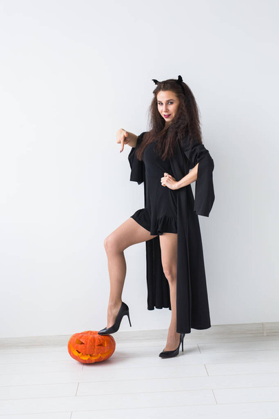 Felice gotico giovane donna in costume strega Halloween sorridente su sfondo stanza bianca
 - Foto, immagini