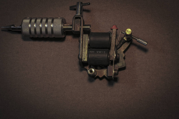 máquina de tatuagem, com acessórios e agulhas, tubos feitos em fundo de cor
 - Foto, Imagem