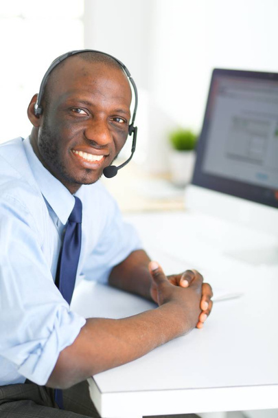 African american businessman on headset working on his laptop - Foto, immagini
