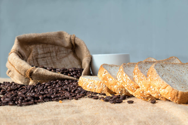 Grano de café negro y pan en rodajas colocados juntos en la arpillera
 - Foto, imagen