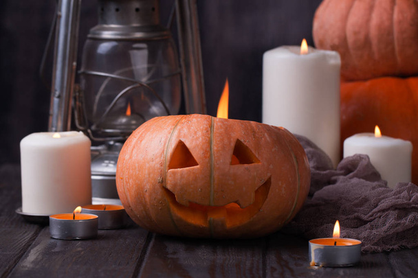 halloween, holidays and decoration concept - jack-o-lantern or carved pumpkins and candles on dark background - Foto, imagen