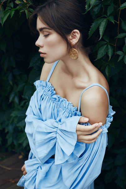 Portret przepiękny brunetka Kobieta w sukni moda niebieski pozowanie w ogrodzie - Zdjęcie, obraz