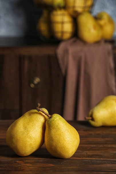 Fresh ripe pears on wooden table against blurred background - Φωτογραφία, εικόνα