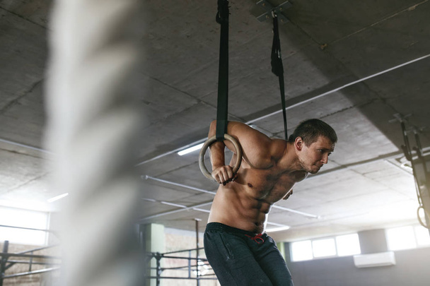 Sports Man Training With Gymnastics Rings At Gym - Foto, Imagen