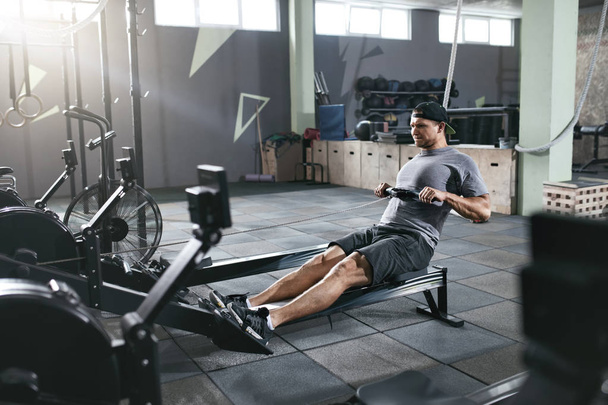 Cardio Training. Sports Man Exercising On Rowing Machine At Gym - Photo, Image