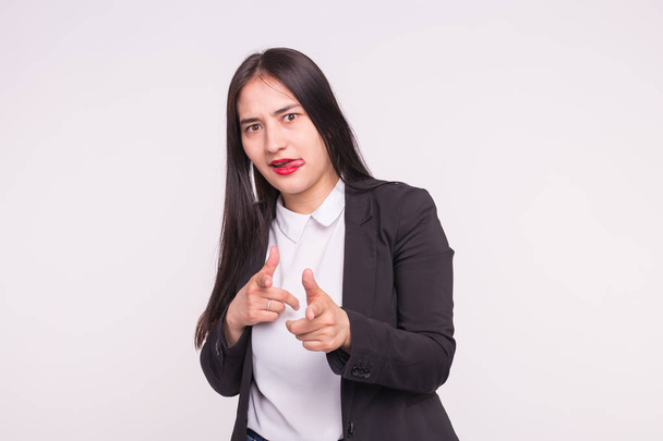 People and gesture concept - asian woman dressed in white shirt and black jacket showing bang-bang gesture over white background - Фото, изображение