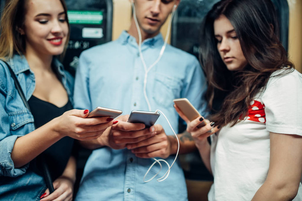 Jovens viciados em telefone usando gadgets no metrô, problema do vício, pessoas viciadas em social, estilo de vida underground moderno
 - Foto, Imagem