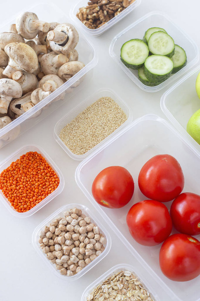 Lagerung vegetarischer Lebensmittel in Plastikbehältern. eine gesunde Ernährung mit Gemüse, Obst, Getreide und Hülsenfrüchten. Ordnung in das Küchenkonzept. Draufsicht, flache Lage - Foto, Bild