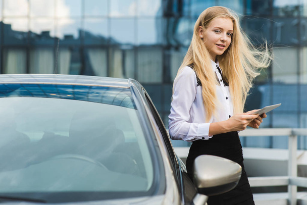 Houkutteleva nuori nainen lähellä auton pito tabletti
 - Valokuva, kuva