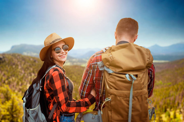 Пара туристов с рюкзаками на вершине горы. Летние походы. Путешествие молодого человека и женщины
 - Фото, изображение