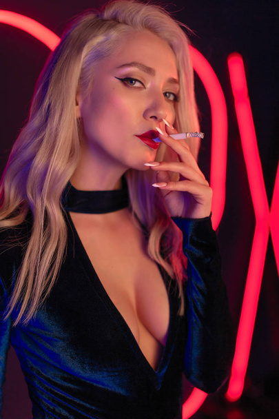 Young blondie woman smoking a cigarette in the open dress - Фото, изображение