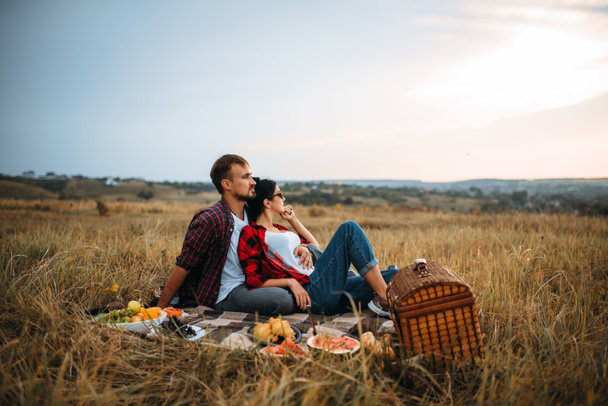 Love couple, picnic on plaid in summer field. Romantic junket of man and woman - Zdjęcie, obraz