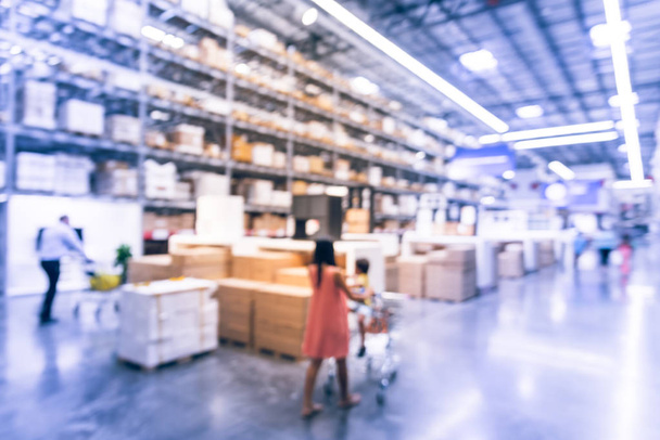 Abstract blurred customer shopping at large furniture warehouse in Texas, America. Defocused interior industrial storehouse full of boxes, row of aisles, bins, shelves, racks from floor to ceiling - Photo, Image