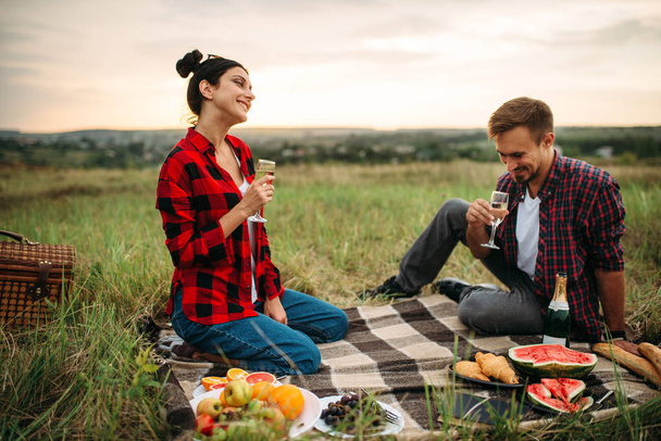 Amor pareja bebe vino, picnic en el prado. Romántico junket, hombre y mujer de ocio juntos, feliz fin de semana familiar
 - Foto, imagen