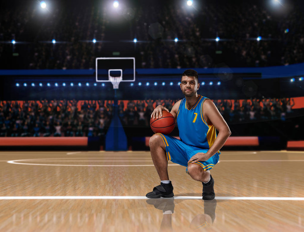 basketbolcu basketbol sahası üzerinde oturan mavi üniformalı - Fotoğraf, Görsel