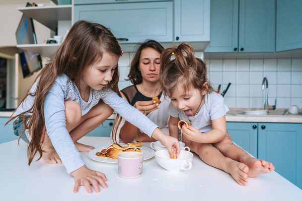 Mom and two daughters eat pancakes - Photo, Image