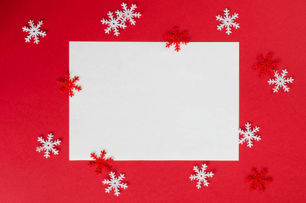 Minimalistische kerstkaart mockup met decoratieve sneeuwvlokken in rode kleur. Lege briefkaart. Xmas achtergrond, bovenaanzicht met kopie ruimte. - Foto, afbeelding