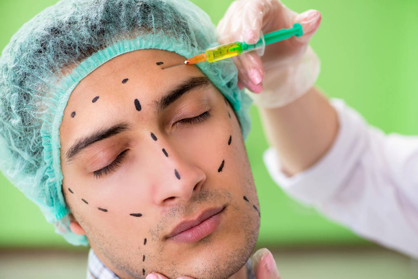 人間の顔で手術の準備をする整形外科医 - 写真・画像