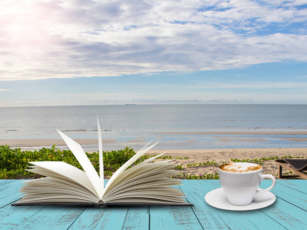A kék fa deszka a tenger part háttérben kávéház csésze nyitott könyv - Fotó, kép