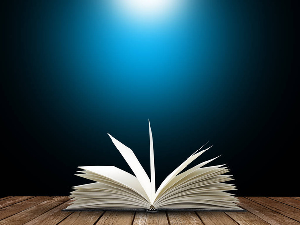 Open boek met blauw licht op zwarte achtergrond - Foto, afbeelding