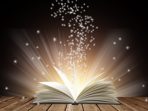 Open book with bright light on black background - Photo, Image