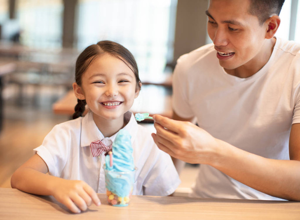 Μικρό κορίτσι με τον πατέρα του τρώγοντας παγωτό  - Φωτογραφία, εικόνα