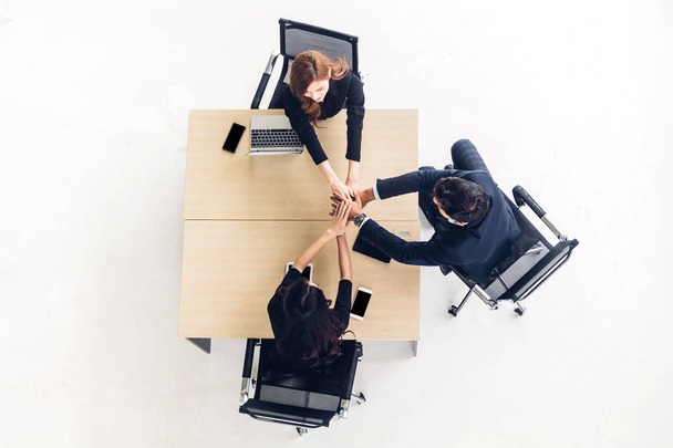 グループ ビジネス人々 スタックとオフィスで木製の机の上に手を一緒に入れて成功の平面図です。友情チームワークの概念 - 写真・画像