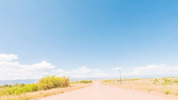 Conducir por el camino de tierra a través del espacio abierto en los suburbios rurales de Colorado
. - Foto, Imagen