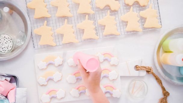 Декорування однокорпусного цукрового печива з королівською глазур'ю для вечірки на день народження маленької дівчинки
. - Фото, зображення