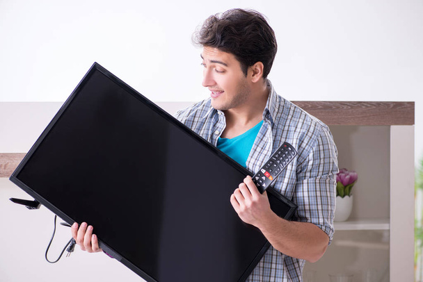 Чоловік намагається виправити зламаний телевізор
 - Фото, зображення