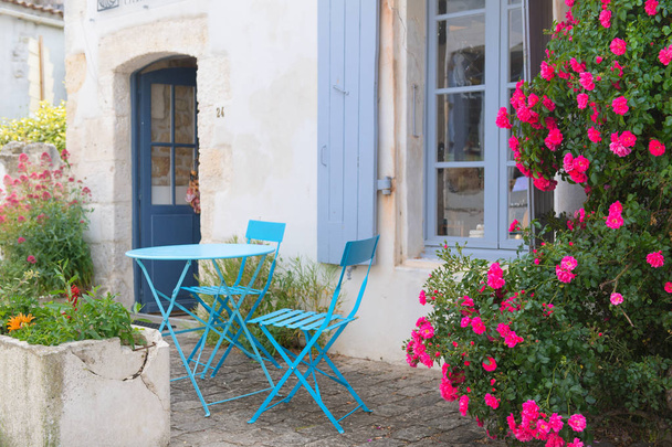 Romantic French terrace with blue bistro set and pink roses - Foto, immagini