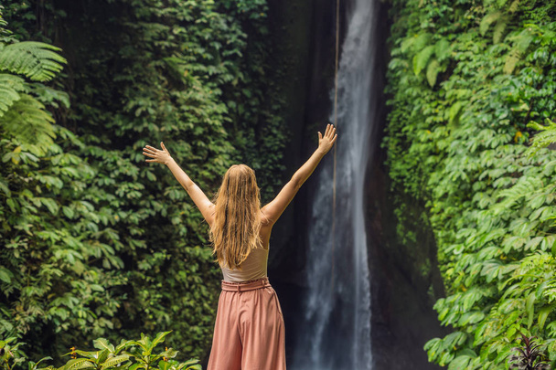 Young female tourist on background of Leke Leke waterfall in Bali island, Indonesia - Zdjęcie, obraz