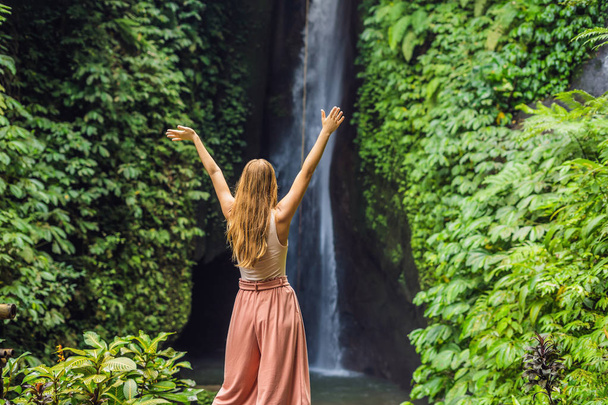 Young female tourist on background of Leke Leke waterfall in Bali island, Indonesia - Foto, Imagem