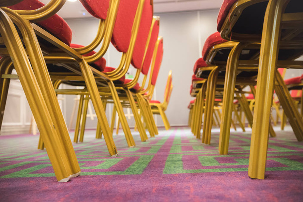 Fila de sillas blandas rojas en una sala de conferencias con una alfombra
 - Foto, imagen