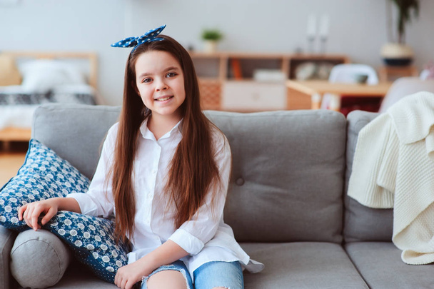 happy 10 years old kid or preteen girl relaxing at home. Cozy living room with modern scandinavian interior, homely lifestyle weekend.  - Fotografie, Obrázek