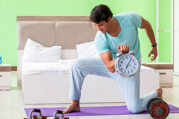 Mladý muž v pyžamu dělá ranní cvičení  - Fotografie, Obrázek