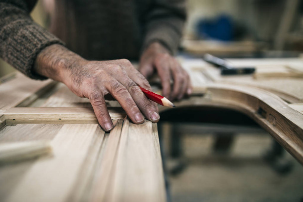 Close up shot of old master carpenter working in his woodwork or workshop - Foto, afbeelding