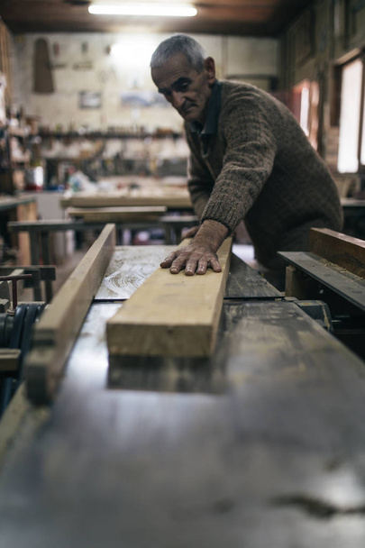 Close up shot of old master carpenter working in his woodwork or workshop  - 写真・画像
